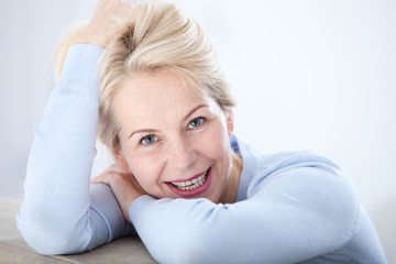 Wall Mural - active beautiful middle-aged woman smiling friendly and looking in camera. woman's face closeup. rea