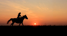 Horseback Woman Riding On Galloping Horse With Red Rising Sun On Horizon. Beautiful Colorful Sunset Background With Equine And Girls Silhouette Horse Hiking