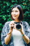 Fototapeta Paryż - Hipster photographer women with camera on green leaf