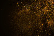 Christmas Gold Sparkle Glitter Explosion Dust Particles Background With Bokeh, Gold Holiday Happy New Year And Valentine Day Concept