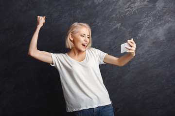 Wall Mural - Happy girl reading good news on mobile