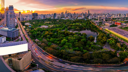 Fototapete - Sunset scence of Bangkok skyline Panorama ,Aerial view of Bangkok modern office buildings and condominium in Bangkok city downtown with sunset sky and clouds at Bangkok , Thailand. Lumpini park
