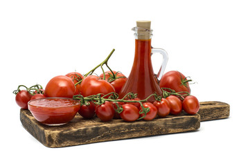 tomatoes and ketchup on a wooden board. 