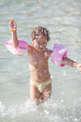little girl is playing in the sea