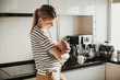 красивая девушка стоит на кухне и держит на руках ребенка a beautiful woman stands in the kitchen holding a baby