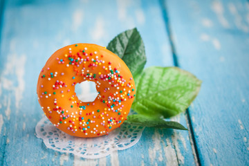 Orange sweet donut with green flower leaves