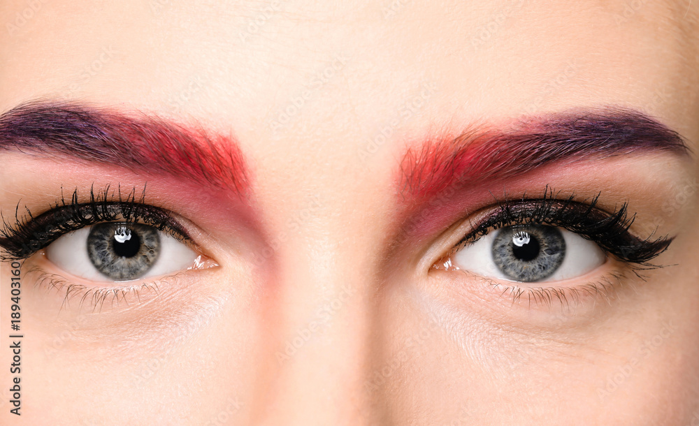 Young woman with dyed eyebrows on white background, closeup
