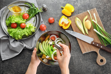 Canvas Print - Woman preparing tasty vegetable salad on table