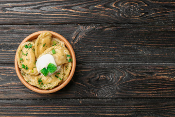 Wall Mural - Bowl with tasty dumplings on wooden background