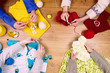 Dressmaker workplace. Group of four woman female knitting warm clothes by knitted needles on wooden background
