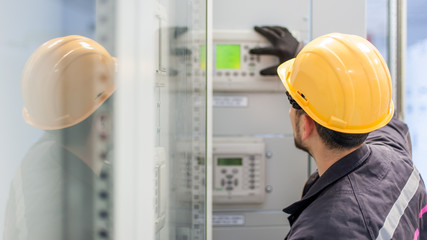 Wall Mural - engineer commissioning bay control unit. engineering department