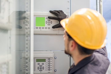 Wall Mural - maintenance engineer testing voltage switchgear and bay control unit