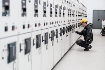 Wall Mural - maintenance engineer testing voltage switchgear and bay control unit