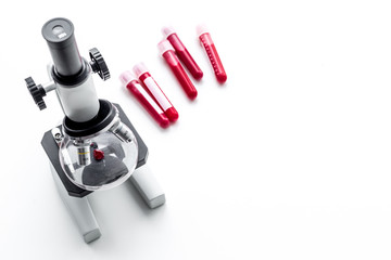 Wall Mural - Blood analysis in clinacal lab. Test tubes near microscope on white background top view copy space