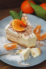 Wall Mural - Piece of Delicious Cheesecake with Tangerine on Gray Plate and Dark Wooden Background. Vertical Image.