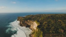 Aerial View Of Sea Rocky Coast With Surf The Waves, Bali,Indonesia, Pura Uluwatu Cliff. Waves Crushing Rocky Shore. Ocean With Waves And Rocky Clif. Seascape, Rocks, Ocean. 4K Video. Travel Concept