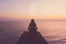 Inspirational Quote " NEW YEAR NEW YOU"with Woman Meditating On A Wooden Bridge By The Sea In The Morning Background With Vintage Filter.