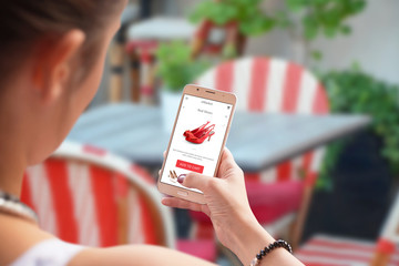 Poster - Online shopping with mobile phone. Red shoes on store web site. Woman use smart phone in coffee shop or restaurant.
