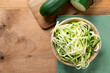 Raw zucchini noodles on a rustic background