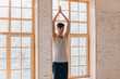 © yuliyalyashok - Relaxed young man doing yoga and meditating in studio