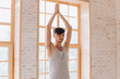 © yuliyalyashok - Relaxed young man doing yoga and meditating in studio