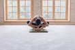 © yuliyalyashok - Relaxed young man doing yoga and meditating in studio