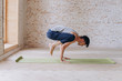 © yuliyalyashok - Relaxed young man doing yoga and meditating in studio