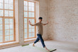 © yuliyalyashok - Relaxed young man doing yoga and meditating in studio