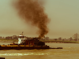 Silhouette of Black smoke from commercial vessel sailing along Irrawaddy river in Mandalay Region, one source of air pollution contribute to global warming/climate change.