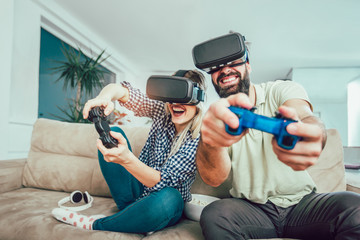 Poster - Happy friends playing video games with virtual reality glasses - Young people having fun with new technology console online