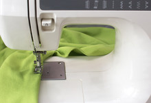 Close Up Of A Home Electric Sewing Machine With Green Fleece Fabric