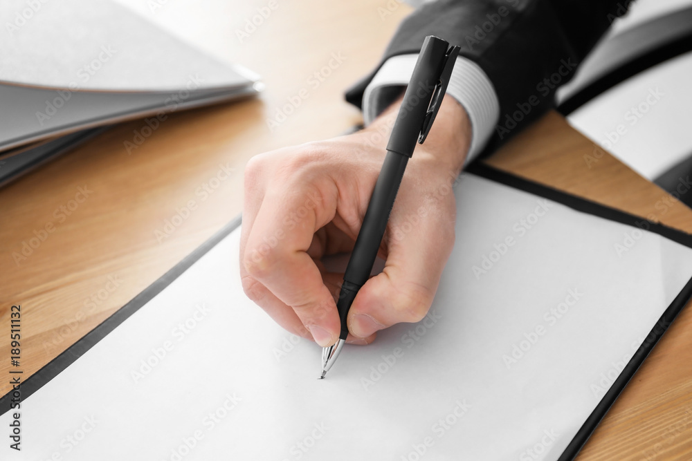 Man writing on sheet of paper, closeup