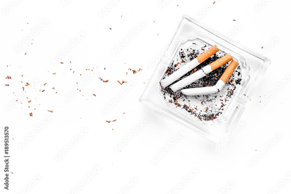 smoking half a cigarette Smoking. Half-smoked cigarettes in ashtray on white background top view  copy space Stock Photo
