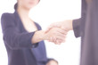 © Wisut - Asian Businesswomen handshake, dark blue and blurred background.