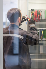 Wall Mural - electrician engineer tests electrical installations on relay protection system