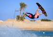 © yanamavlyutova - Wake boarding female sportsman girl jumping high wake boarding raley trick with huge water splash in the cable park, active sports, life style, recreation hobby fun, rider woman on the air background