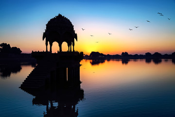 Fototapete - Gadi Sagar lake (Gadisar) at Jaisalmer, Rajasthan with ancient temple at dawn.
