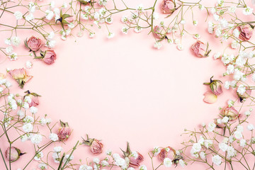 Poster - Frame of small delicate white flowers and roses on pink background. Place for text.