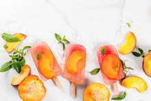 Summer Desserts. Frozen Drinks. Sweet Fruit Popsicles From Frozen Peach Tea With Mint. On A White Marble Table, With Ingredients - Peaches, Mint, Ice. Copy Space Top View