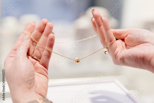 Fotografía Woman owner of jewelry shop presenting gold necklace.