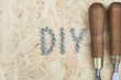 Dłuta oraz napis DIY na drewnianym tle