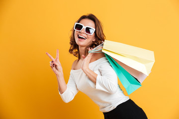 Poster - Happy young woman holding shopping bags