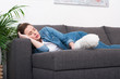 © LIGHTFIELD STUDIOS - tired woman with dust cleaning brush in hand sleeping on sofa at home