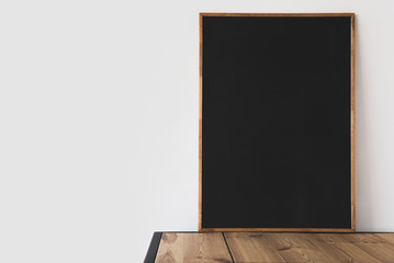 Canvas Print - one big empty blackboard on wooden table on white