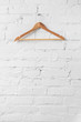 one brown wooden hanger on white wall
