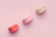 Top view of mini pink and white macaron on soft sweet pink paper background
