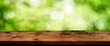 Green bokeh background with wooden table