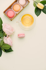 Sticker - Colorful macaroons and rose flowers with tea on light green. Sweet macarons in gift box. Top view