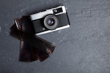 Vintage Camera And Film Negatives On A Slate Background