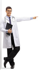 Poster - Doctor with a clipboard leaning against a wall and pointing